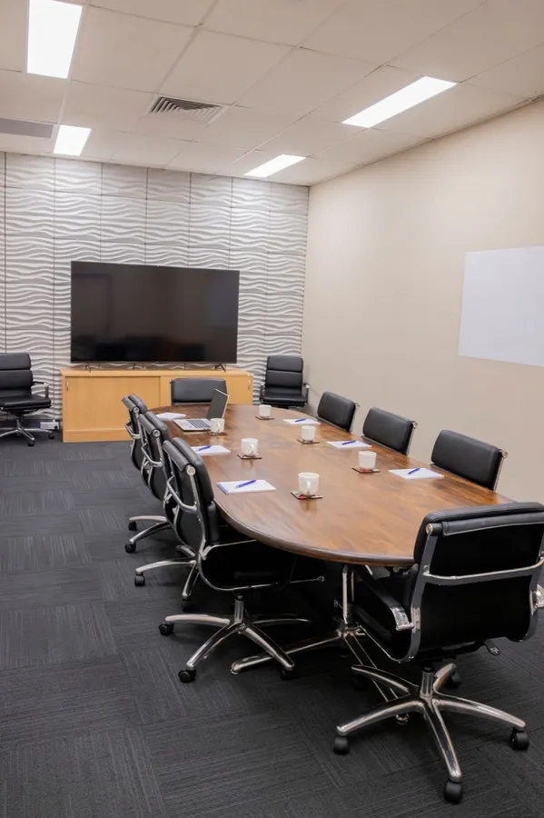 The Hub board room, an oval timber table for ten with a wall screen