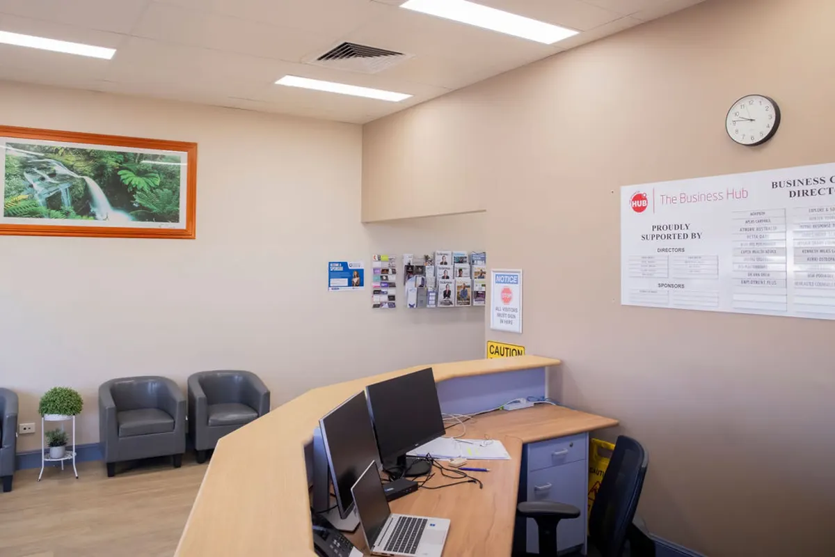 The Hub entry foyer, with member business cards and brochures displayed on the wall beside reception