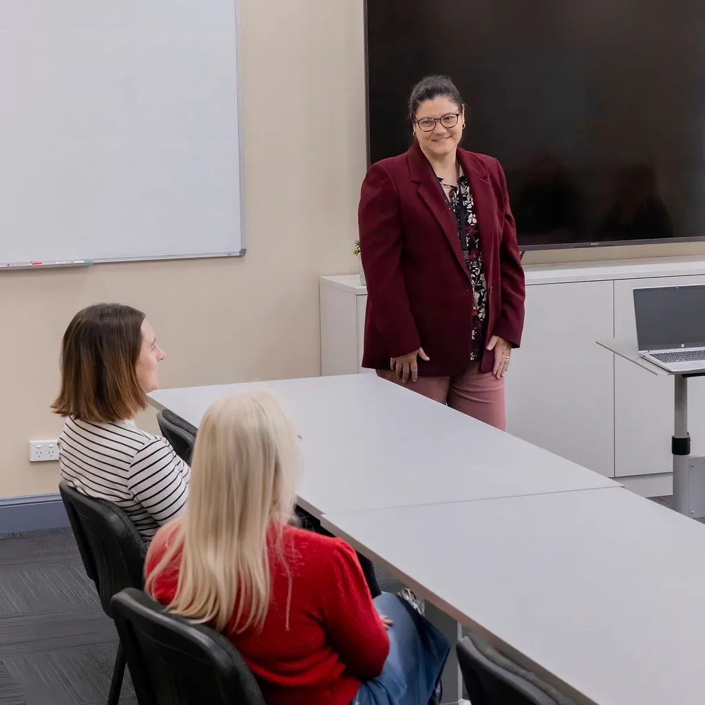 A presenter leading a training session for attendees in the Hub training room
